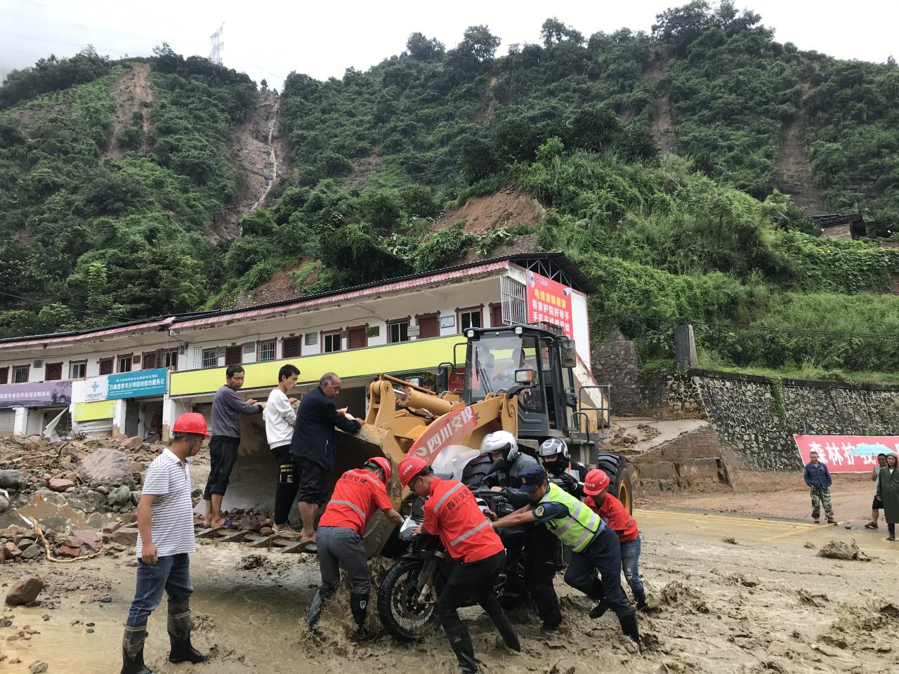 8月18日，搶險人員與民警幫助被困群眾的摩托車(chē)通過(guò)涉水路面.jpg